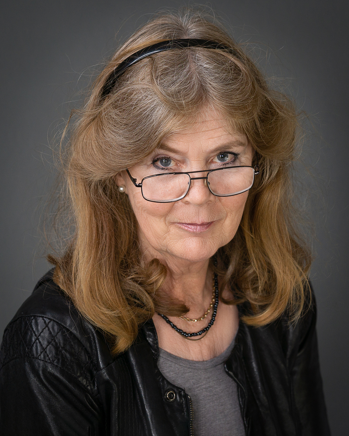 Headshot of a lady with glasses and leather jacket