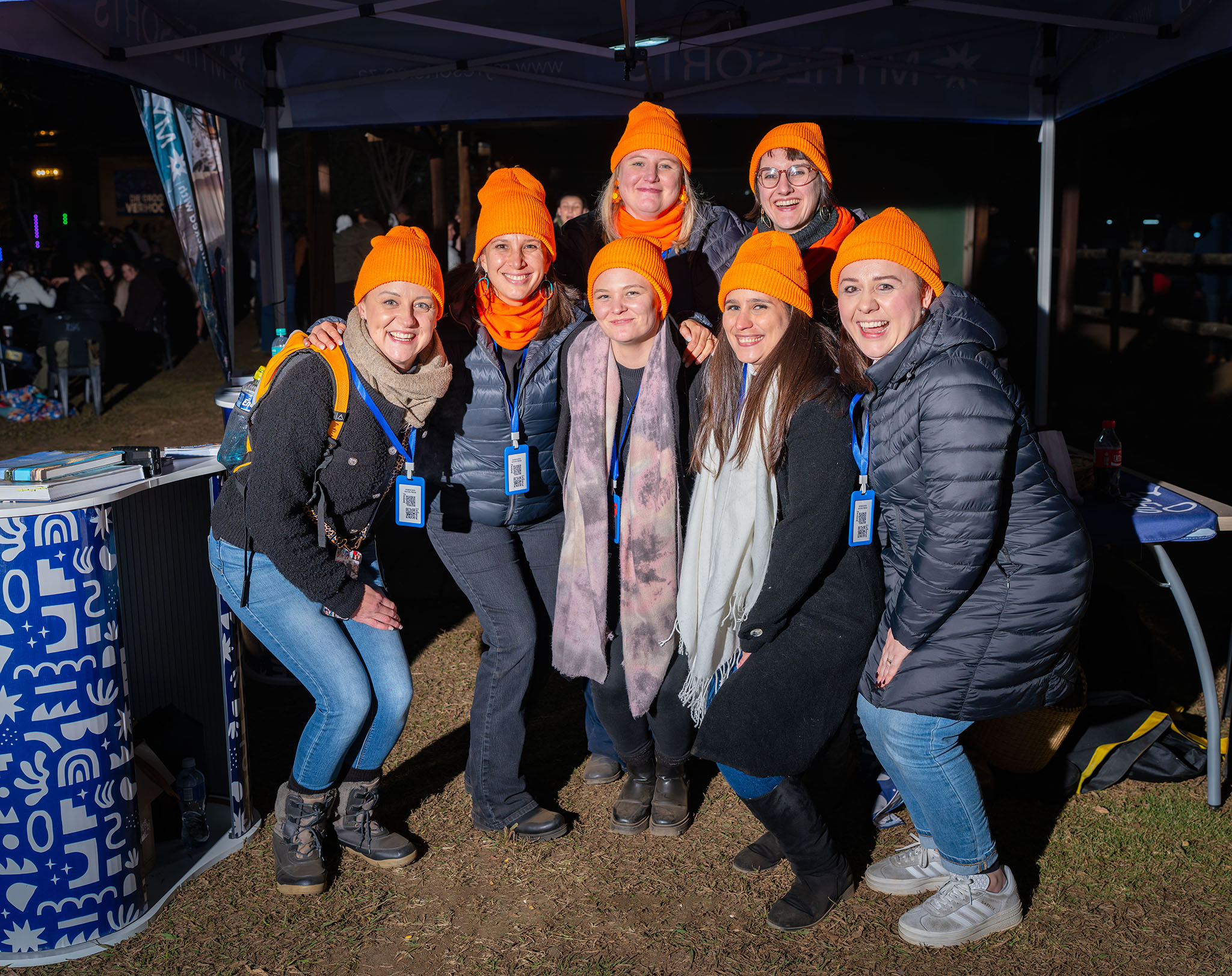 A team smiles at the camera at a night event