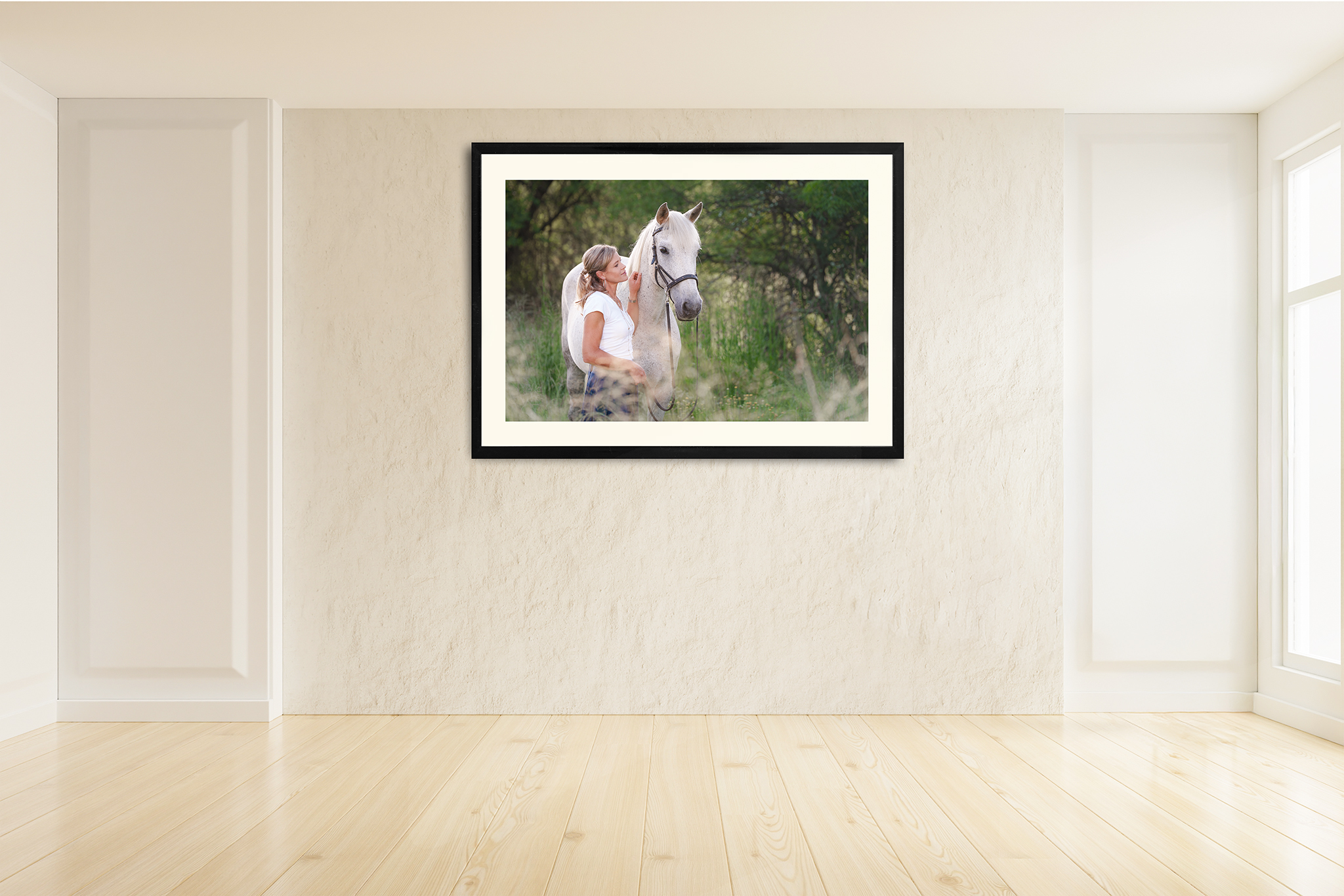Woman standing beside her white horse in a natural outdoor setting, photographed in soft morning light
