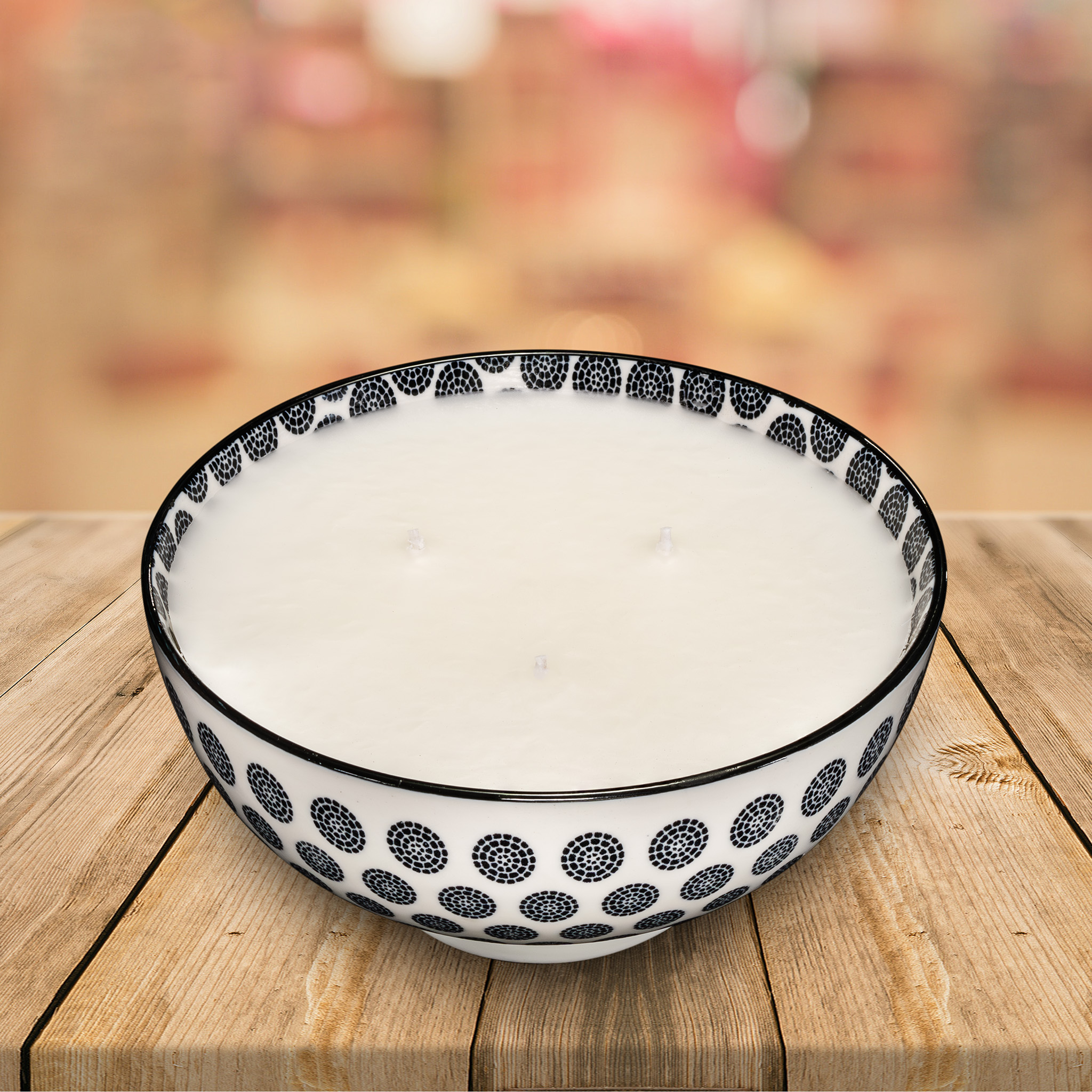 Styled prosuct shot of a scented candle in a patterned ceramic bowl