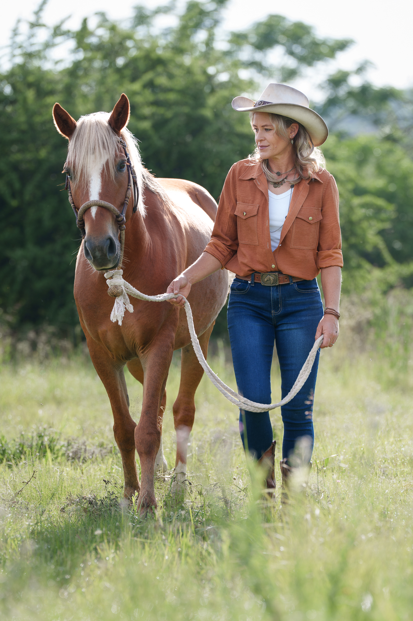 Portrait of a lady in western clothing with her horse