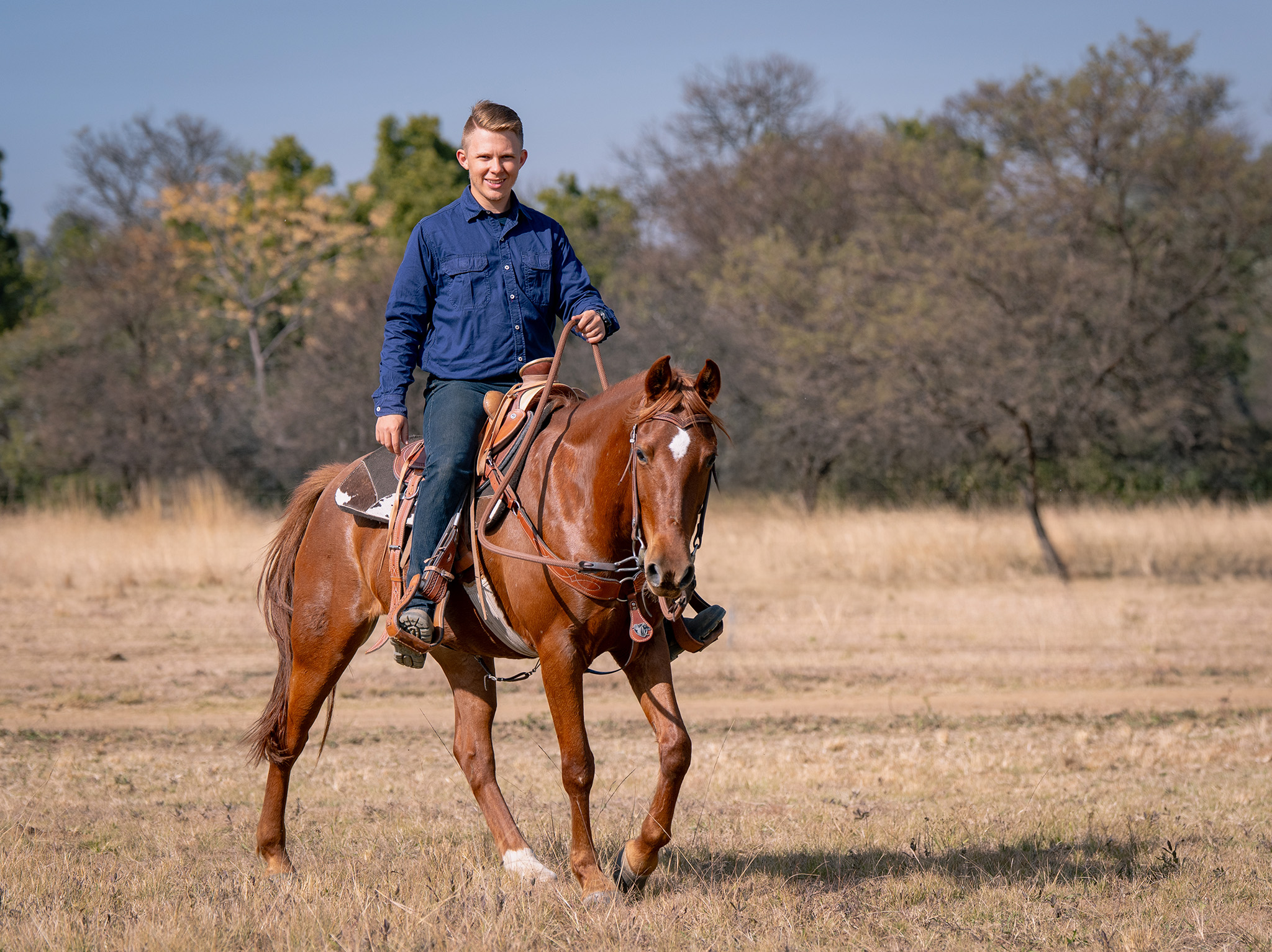 A western rider with an arabian horse in Africa