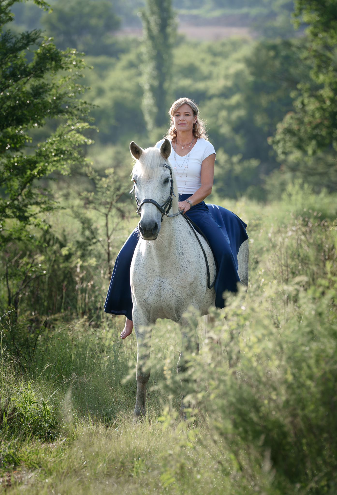 Portrait of a rider in a royal blue skirt on a grey horse
