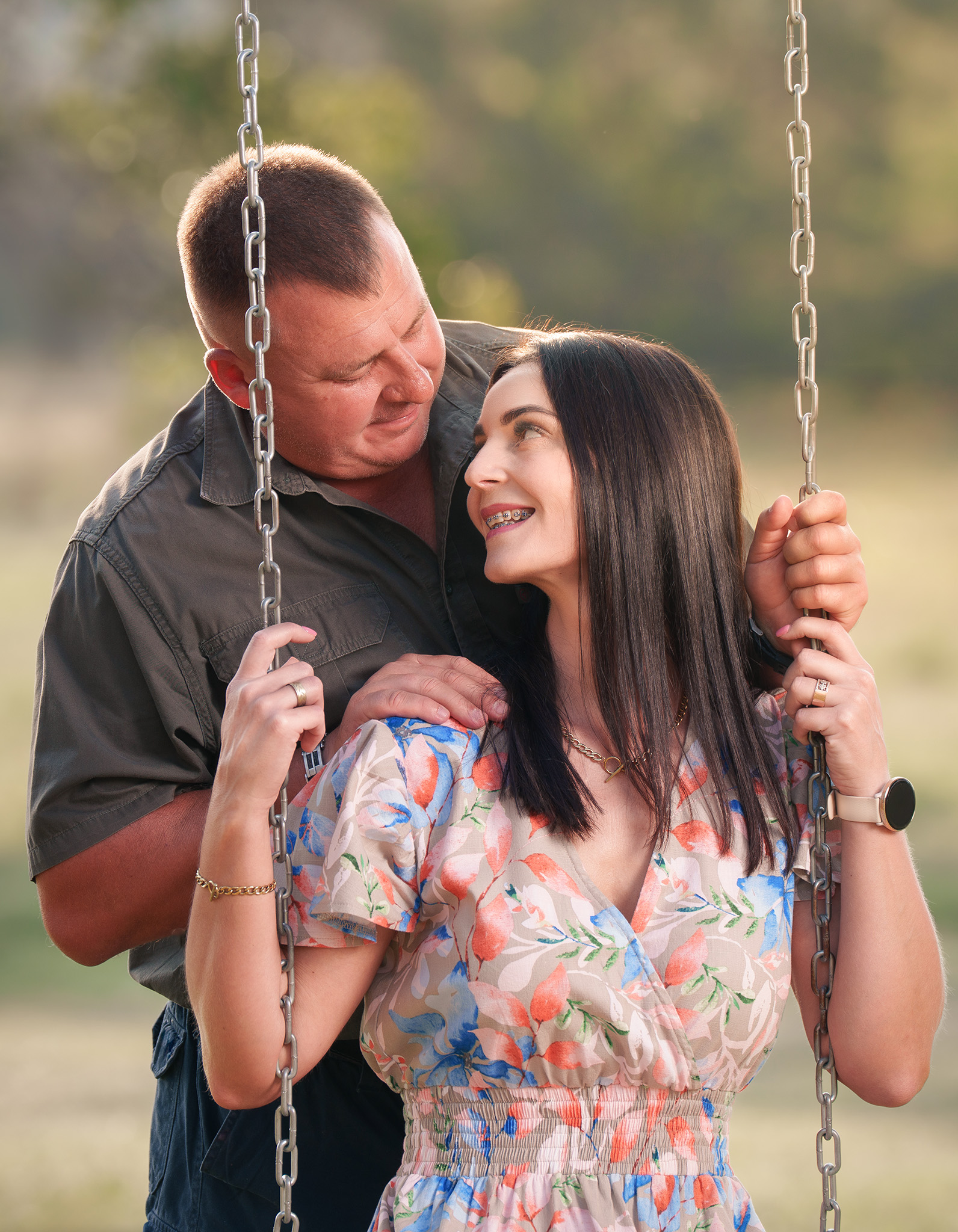 Golden hour portrait of a happy couple sharing a moment on a swing