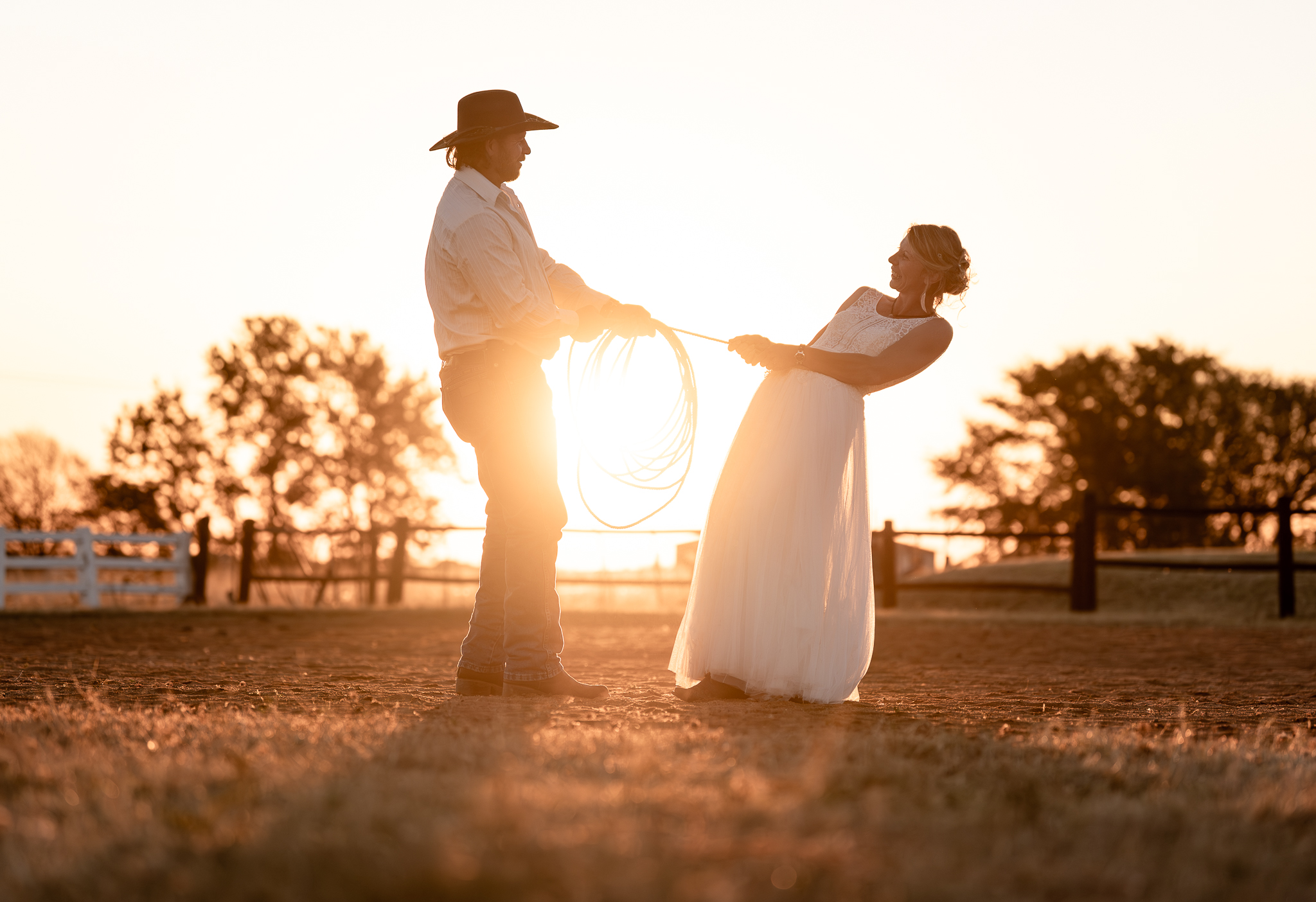 A fun moment captured of a happy wedding couple with a western theme at dusk