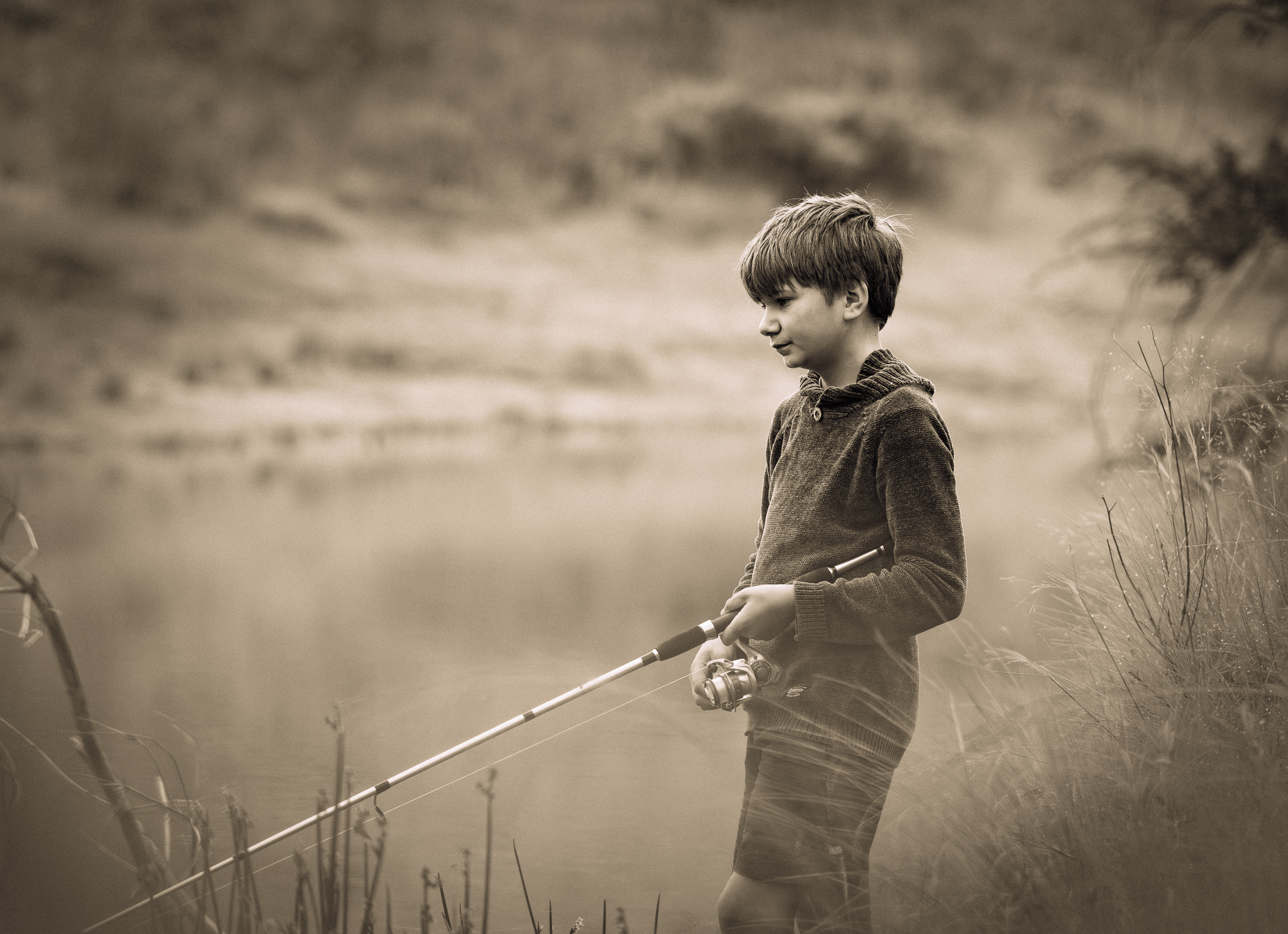 Portrait of a boy fishing in sepia tones