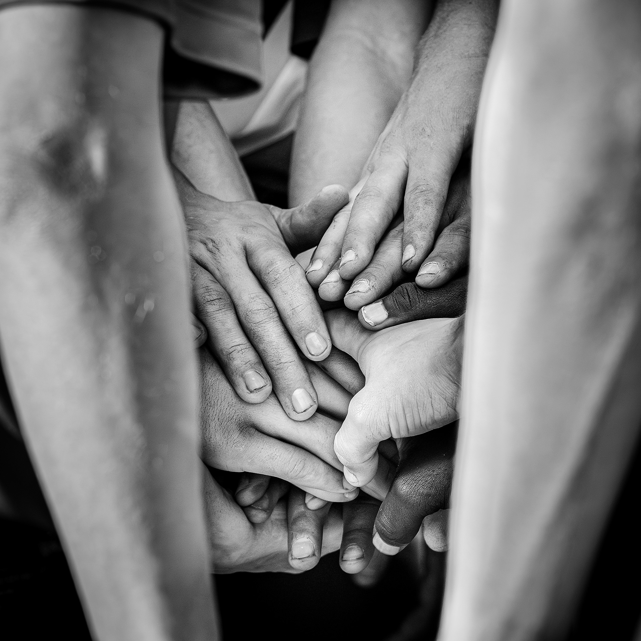 Black and white image of hands of a softball team