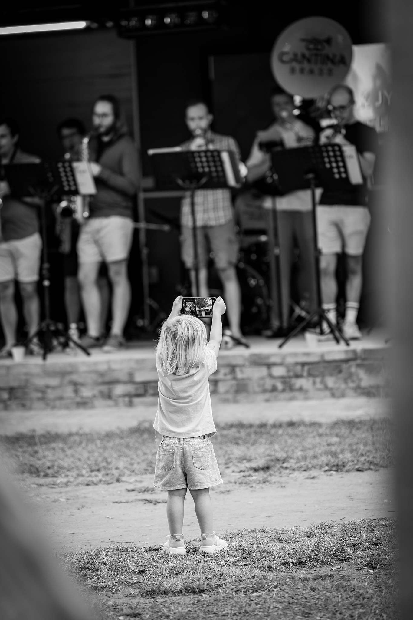 A todler takes a video of a band on stage