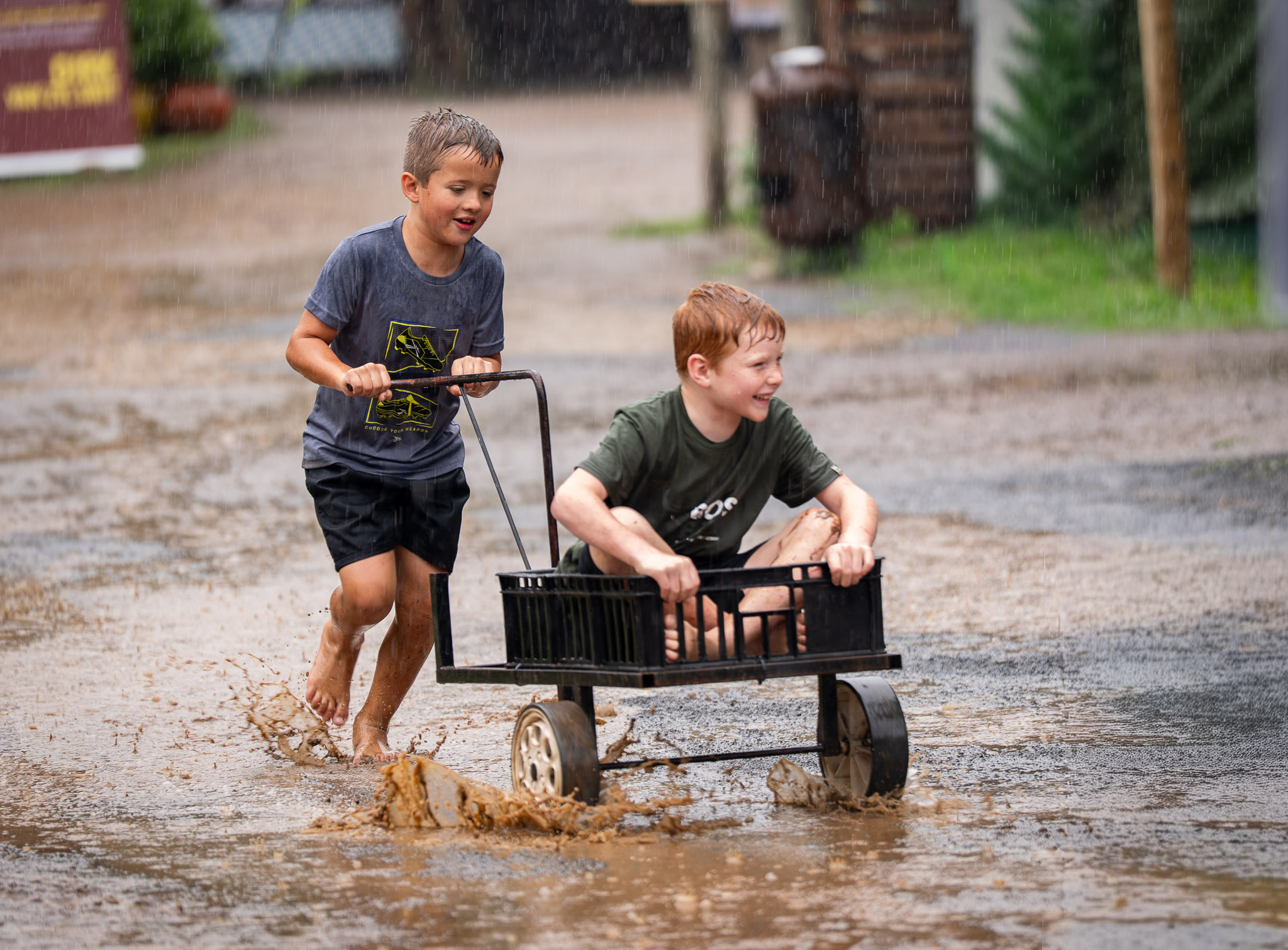 Boys play in the water after a rainstorm at a local market