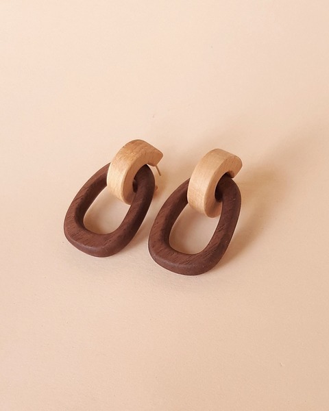 Hand carved Linked Hoop Earrings in Dark Walnut and Beech Wood with a Sterling Silver ear pin.  Although these earrings are of a larger scale, they super light and comfortable on the ear.  The earrings are two tone of Dark wood (Walnut) with a Light wood (Beech) and is available in either top hoop part in Beech wood with Dark Walnut bigger bottom hoops and the other version of top hoops in Dark Walnut and the bigger bottom hoops in Beech Wood. The top smaller hoops fit snugly on the ear with a opening at the back where the silver pin enters the ear lobe.Dimensions: Total hanging length 5cm                      Width 2,8cm and                      Thickness of hoops 0,6cmwith a total weight of 3,6 grams per earring. 