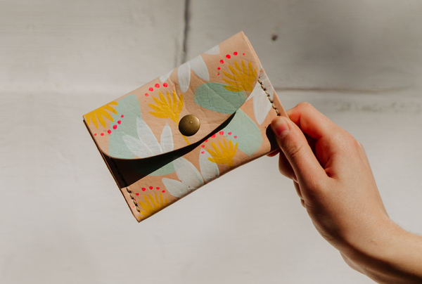 PLEASE NOTE THAT WE HAVE A 7 - 14 DAY PRODUCTION LEAD TIME FOR ALL PRODUCTS, AS THEY ARE MADE TO ORDER.The Mini purse is hand crafted using locally sourced leather. It is hand painted using a specially formulated leather paint. As the pattern is hand painted, please expect slight variations from product to product. Dimensions: H 9cm x W 13cm x D 0.5cm Features a press stud closure and an internal division. Perfect for coins, cards and notes, or small valuables and trinkets. Please note that Ilundi products are made with the finest quality materials available. Any irregularities in the colour or in the grain are normal characteristics of natural leather. Leather items may have wrinkles, scars or scratches, that are an inherent quality and natural beauty of the hide.  SHIPPING:South African orders sent with Dawn Wing, 2-3 working days (over and above the production lead time).International orders sent via DHL. Fees automatically calculated at checkout. All customs fees to be paid by the receiver.