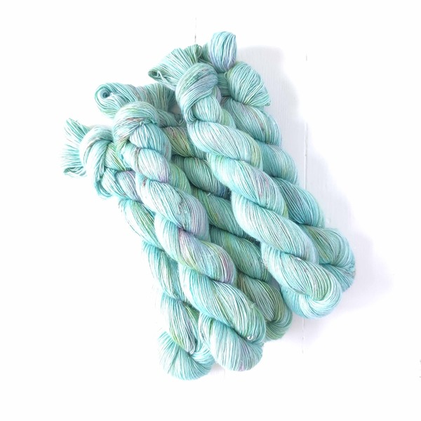 Vagabond was one of the first colours I ever dyed back in the mists of time. It's a delicate aqua-mint pale variegated type colourway - layered with hints of mint green, seaglass and a hint of cool rose. Delicate speckles provide pops of contrast. 
Vagabond pairs very well with neutrals like Linen or Ash - providing some pop and fresh colour to the neutrals.
Care Instructions: For long term fibre and colour care a gentle, PH neutral detergent (preferably natural/organic) and cold water rinse is recommended. Refrain from excessive wringing. Dry flat, avoiding prolonged exposure to harsh sunlight.