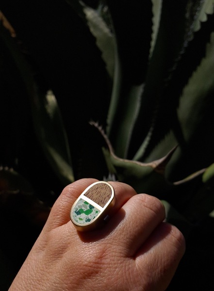 Handcrafted Pill shaped Brass setting with a Wood and Terrazzo Clay inlays on a solid 925 Sterling Silver ring.
The Rings are availabe in various colours combinations off wood and clay:
White Terrazzo Clay with Green chips details matched with Dark Walnut Wood
Olive Terrazzo Clay with Ochre + Cream + Maroon chips details matched with Dark Walnut Wood
Marroon Terrazzo Clay with Neon ships details mathced with Imbuia Wood
Turquoise Terrazzo Clay with Navy + Ochre + Terracotta + White chips detail matched with Iroko Wood
 
The rings are currently all availble in the UK Ring size P (inner ring dimension of 1,8cm).  Please specify when ordering if the ring size needs to be adjusted, we can make them to order in any size specified. 